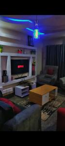 a living room with a couch and a tv and a table at Abasis apartment in Abeokuta