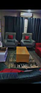 a living room with two chairs and a coffee table at Abasis apartment in Abeokuta