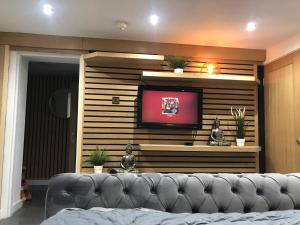a living room with a couch and a tv at Hendham House in Manchester