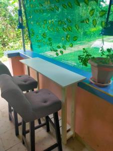 a table and two chairs in front of a fish tank at Mini farmhouse in Kakamega +2 photos