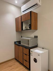 a kitchen with a microwave and a refrigerator at سكينة هاوس in Riyadh