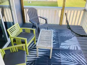 two chairs and a table on a porch at Saltwater Solace For 8 in Galveston