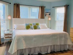 a bedroom with a large white bed with two pillows at Saltwater Solace For 8 in Galveston +60 photos