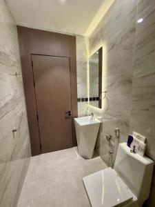 a bathroom with a sink and a toilet and a mirror at سكينة هاوس in Riyadh