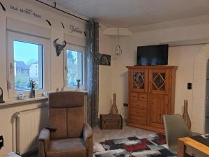 a living room with a chair and a television at Schneeglöckchen in Marl