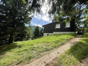a black house on a hill with a dirt road at T2 Vassiviere in Le Lioran