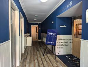 um corredor com paredes azuis e uma placa em uma sala em The Lodge by Cefn Tilla em Usk
