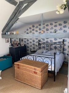 una camera da letto con un letto con carta da parati blu e bianca di Chez Valerie et Francois a Moux-en-Morvan