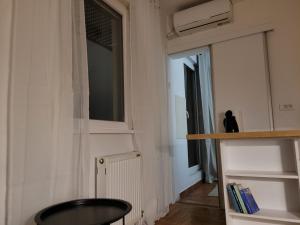 a room with a chair and a window and a shelf at APARTMANI Emerald Dream in Novi Sad