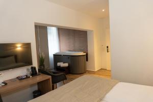 una camera da letto con un letto, una scrivania e una televisione di Hotel Work Life Residence am Bahnhof a Winterthur