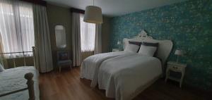 a bedroom with a white bed and green wallpaper at Close to centre, 3 rooms, 2 bathr & wc, free parking & wifi, spacious living area & kitchen in Bruges