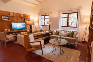 a living room with a couch and a tv at Madaro House in San Antonio de Arredondo