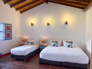 two beds in a room with two lamps on the wall at Dreamer Cocora in Salento +35 photos