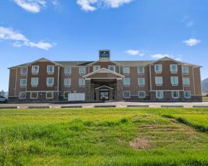 a large brick building with a lawn in front of it at Cobblestone Hotel & Suites - Ephraim in Ephraim