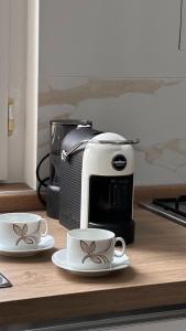 a microwave and two coffee cups on a counter at Casa di Tatiana in Chiappa