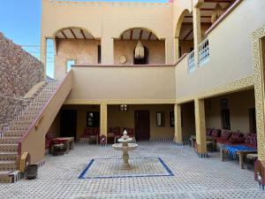 a courtyard with a fountain in the middle of a building at Riad camels house in Merzouga