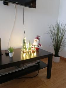 un Babbo Natale seduto su un tavolo con due alberi di Natale di Pombinhos Douro a Peso da Régua