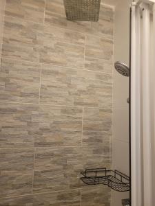 a bathroom with a wooden tile wall at APARTMANI Emerald Dream in Novi Sad