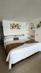 a bedroom with a large bed with white sheets at Suite en torres gemelas vista al mar in Acapulco