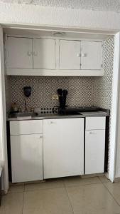 a kitchen with white cabinets and a sink at Suite en torres gemelas vista al mar in Acapulco +28 photos