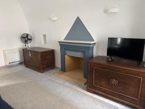 a living room with a fireplace and a tv at Alexander House 1 in Leonidio