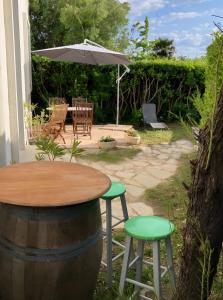 奥雷龙圣皮耶尔Appartement À Saint-Pierre-d'Oléron的院子里的桌子和椅子以及雨伞
