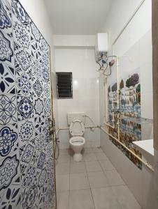 y baño con aseo y azulejos azules y blancos. en Hestia by Ghorsirika, en Guwahati 7 fotos más