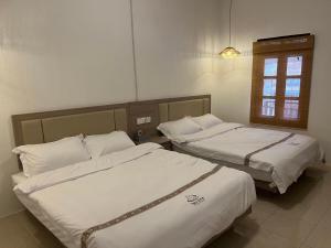 duas camas em um quarto com janela em Tea time B&B em Luang Prabang