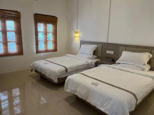 um quarto com 2 camas e 2 janelas em Tea time B&B em Luang Prabang