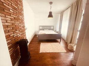 a bedroom with a bed and a brick wall at Weener - City Apartment mit Garten in Weener
