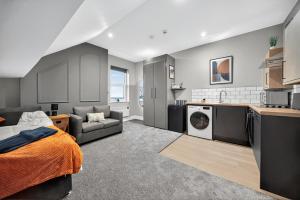 a living room with a bed a couch and a kitchen at Rosemont ApartHotel in Leeds