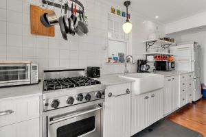 a white kitchen with a stove and a sink at Waterfront with Private Beach Stunning Views in Provincetown