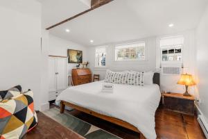 a bedroom with a large white bed and a table at Waterfront with Private Beach Stunning Views in Provincetown