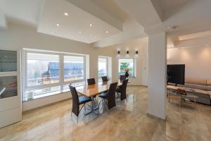a dining room and living room with a table and chairs at Villa Grande in Odorheiu Secuiesc