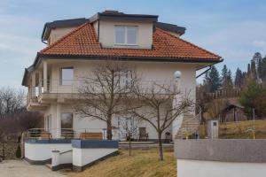 a white house with an orange roof at Villa Grande in Odorheiu Secuiesc