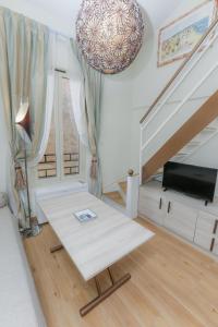 a living room with a white table and stairs at Loft Moderne - À Deux Pas de Monte-Carlo in Roquebrune-Cap-Martin
