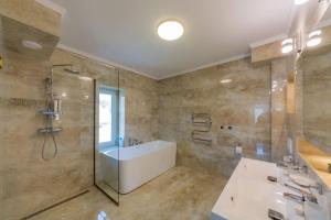 a bathroom with a shower and a tub and a sink at Villa Grande in Odorheiu Secuiesc +37 photos