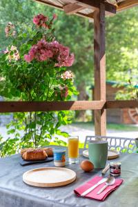Touët-sur-VarにあるLe Githotelの食べ物の皿とピンクの花が入った花瓶が置かれたテーブル