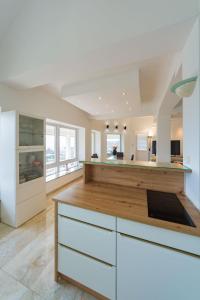 a kitchen with white cabinets and a wooden counter top at Villa Grande in Odorheiu Secuiesc
