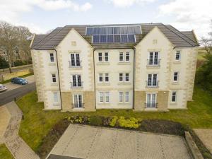 a large house with solar panels on top of it at Royal Gardens Apartment 19 in Dornoch +5 photos
