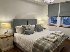 a bedroom with a large bed with two pillows at Royal Gardens Apartment 19 in Dornoch