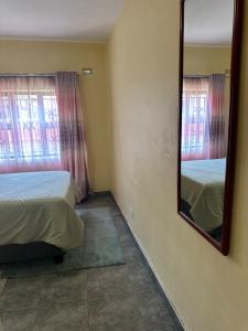 a bedroom with a mirror and two beds in it at Hatfield - Staylax Manor 3 in Harare
