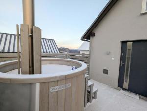 a hot tub on the side of a house at Wellness Minikvítek in Smržovka