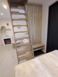 a wooden staircase in a room with a fireplace at Wellness Minikvítek in Smržovka