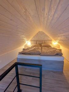a bed in a room with a ceiling at Wellness Minikvítek in Smržovka