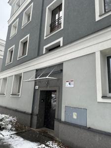 a gray building with a door and a window at Apartament Tuwima 2 in Zabrze