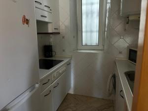 Una cocina con gabinetes blancos y un fregadero y una ventana. en Semidiáfano Santa Teresa, en Ávila 3 fotos más