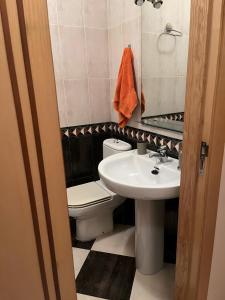 Un baño con lavabo, inodoro y espejo. en Semidiáfano Santa Teresa, en Ávila