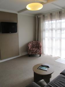 a living room with a couch and a chair at Lake Rotorua Hotel in Rotorua