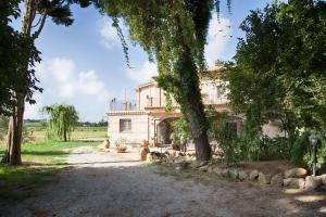 an old house with trees in front of it at Don Carlo Agriturismo di Charme Bio in Le Pioppe